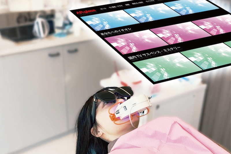 ARグラスで動画を観ながら、ホワイトニングの照射を受ける患者